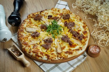 Eritilmiş peynirli, tavuklu, mısırlı ve ahşap tepside yumuşak biftekli Meksika pizzası. Üst Manzara. Yemek düzdü.