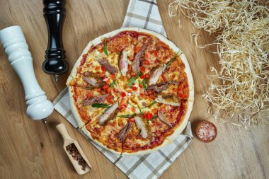 Eritilmiş peynirli, domuzlu, ahşap tepside domatesli ve malzemeli iştah açıcı pizza. Üst Manzara. Yemek düzdü.