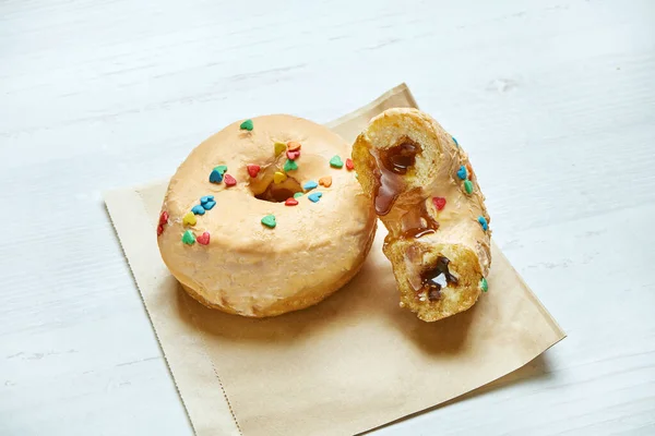 Eet Donut Met Gele Glazuur Karamel Vulling Ambachtelijk Papier Een — Stockfoto