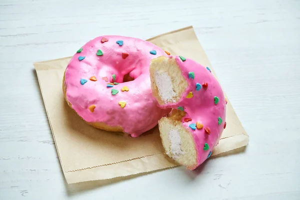 Eet Donut Met Roze Glazuur Aardbeienvulling Ambachtelijk Papier Een Houten — Stockfoto