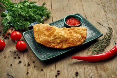 Geleneksel Kafkas yemeği Cheburek 'tir, farklı dolguları olan kızarmış bir turta, çoğunlukla mavi tabakta et veya peynir..