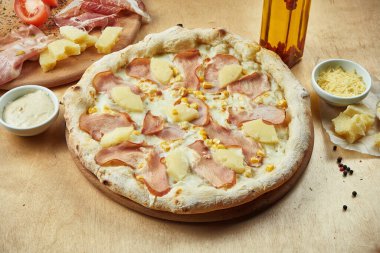 İştah açıcı pizzayı İtalyan parma jambonu, mozzarella, ananas ve mısır ile yakın plan bir restoranda. İtalyan mutfağı.