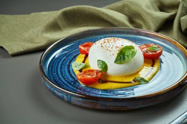 Ahşap arka planda mavi tabakta şeftali kremalı mozzarella ile İtalyan burrata peyniri. Lüks Restoran Yemekleri. Kapat, boşluğu kopyala