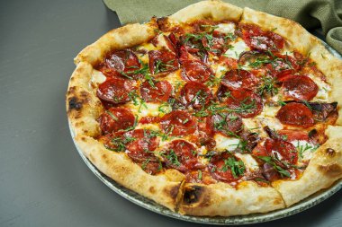 Restoranda ahşap arka planda baharatlı sucuklu salamlı iştah açıcı pizza. İtalyan mutfağı. Yaklaş, seçici odaklanma