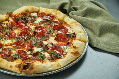 Restoranda ahşap arka planda baharatlı sucuklu salamlı iştah açıcı pizza. İtalyan mutfağı. Yaklaş, seçici odaklanma