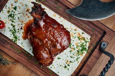 Alman ve Çek mutfağının klasik bir yemeği ahşap bir tahtanın üzerinde bira ve bal soslu domuz etidir. Bira çerezi. Lezzetli yemekler yakın plan. Kızarmış domuz budu, Eisbein.