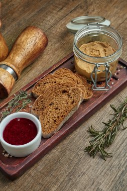 Taze ev yapımı Kaz ciğeri ezmesi, çavdar ekmeği ve ahşap tepside reçel. Lezzetli restoran yemeklerinin en iyi manzarası. Aperatif