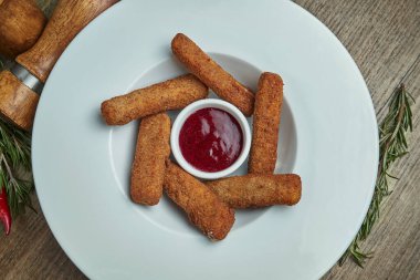 Ahşap arka planda reçelli beyaz tabakta kızarmış mozzarella peyniri çubukları. Lezzetli bira..