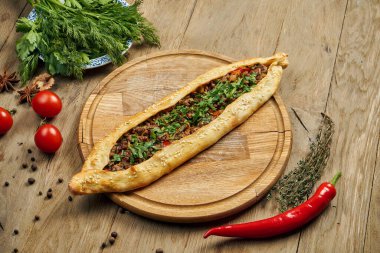 Pide - Tahta tepside sığır eti, kuzu kıyması ve yeşil soğanlı tortilla şeklinde Türk yemeği. Oriental pizza, yemek tarifi veya menü