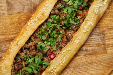 Pide - Tahta tepside sığır eti, kuzu kıyması ve yeşil soğanlı tortilla şeklinde Türk yemeği. Oriental pizza, yemek tarifi veya menü