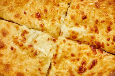 Close up view on tasty traditional Khachapuri - closed baked pie stuffed with melted salt cheese (suluguni) or meat on wooden tray. Traditional georgian food clipart