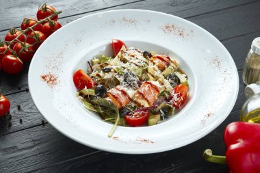 Lezzetli Nicoise Salatası, koyu arka planda, sindirimli beyaz kase servis ediyordu. Salatayı roka, bıldırcın yumurtası, domates ve somonla kapat.