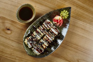 Lezzetli, bol yağda kızartılmış suşi rulo yengeci, soya soslu siyah tabakta tobiko havyarı. Japon yemeği.