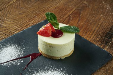 Hassas Airy Cheesecake 'in ahşap arka plandaki lezzetli dilimine yaklaş. Yemekten sonra lezzetli tatlı pastası. Tarif veya menü için yemek fotoğrafı arkaplanı