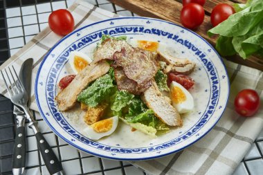 Ceasar salatası, kızarmış ekmek, parmesan, tavuk, yumurta ve beyaz bir kase. Restoran servisi. Seçici odak, tahta arkaplan