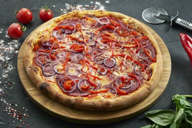 Bol malzemeli pizza: sosis, soğan, salam, peynir ve biber. Siyah arka planda bileşenleri olan pizza.