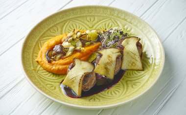 Tatlı patates püresi, Worcestershire sosu ve beyaz ahşap arka planda yeşil bir tabakta patlıcan ile dana madalyonu. Manzarayı kapat. Uzayı kopyala Lezzetli yemek.