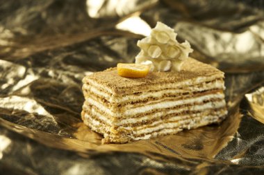 Katmanlı ballı pasta ve altın kaplama kremalı pasta. Bir dilim lezzetli Medovik keki. Kapatın. Lezzetli fırın konsepti. Seçici odak