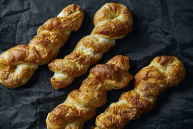 Vertuta 'ya yakın çekim - egzoz hamurundan siyah arka planda elmayla yuvarlanma. Moldova ve Ukrayna mutfağının lezzetli ve lezzetli hamur işleri. Üst Manzara. Seçici odak