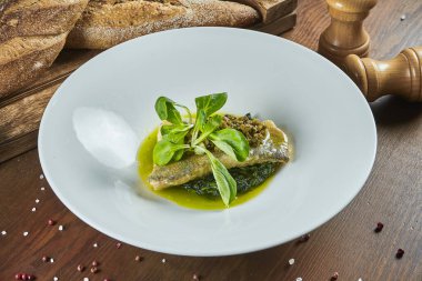 Yeşil soslu haşlanmış ıspanak yastığının üzerinde ızgara turna balığı filetosuna yaklaş. Sağlıklı yiyecekler. Restoran yemekleri..