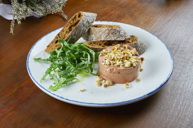 Taze ev yapımı kaz ciğeri baget, roka, fındık ve mantar balı ahşap arka planda beyaz tabakta. Lezzetli restoran yemeklerini yakın..