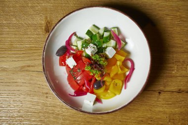Beyaz bir kasede domatesli Yunan salatası, peynir, soğan, salatalık ve dolmalık biber. Üst Manzara. Sağlıklı yiyecekler. Fitness beslenme ve diyet