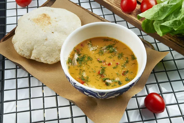 CLose up view on tasty lentil cream soup with focaccia bun in beautiful ceramic bow served on parchment on white background — Stock Image Close View Tasty Lentil Cream Soup Focaccia Bun Beautiful Ceramic Royalty Free Stock Images