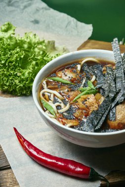 Ramen çorbasıyla vejetaryen kasesi, şitake mantarı, taze sebzelerle kompozisyonda ahşap tepside soya eti. Sağlıklı yemek..