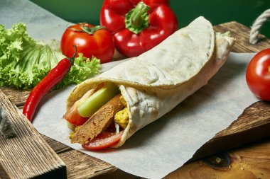 Soya sosisi, sebze ve kızarmış soya peynirli vejetaryen shawarma rulosu. Lezzetli, sağlıklı ve yeşil yiyecekler. Vejetaryen sokak yemeği