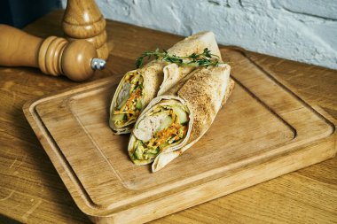 Tahta bir tahtanın üzerinde tavuk kebabı, sos ve sebzeli taze ekmek. Sokak yemeği. Shaurma veya shawerma