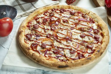 Domatesli, peynirli, sosisli, kırmızı soslu ev yapımı etli pizza. Çıtır pizzalı kompozisyon, arka planda domatesler. Uzayı kopyala Üst görünüm