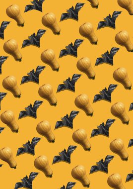 Sarı arka planda yarasalar ve balkabaklarından oluşan yaratıcı minimalizm deseni. Cadılar Bayramı planı. Poster için düz zemin. Ürkütücü bir tatil