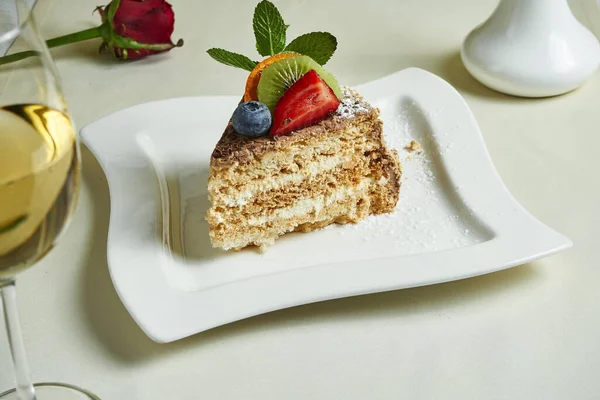 Famous traditional Kiev cake (Hazelnut Daquoise cake) on a white plate. Tasty meringue layers and vanilla buttercream dessert. Food flat lay with desset