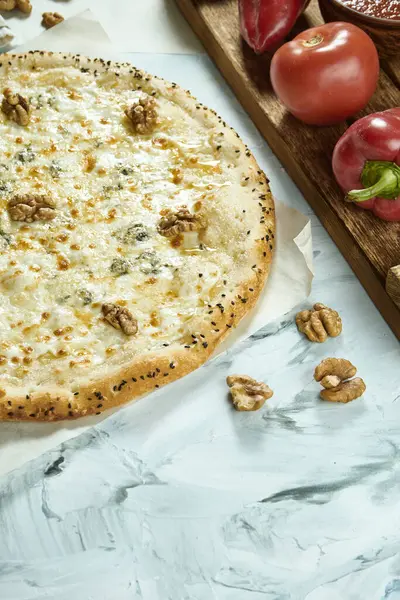Hafif arka planda cevizli dört peynirli İtalyan pizzası. Pizza, sos ve domatesli kompozisyon. Kopyalama alanı olan üst görünüm. Düz yatıyordu. Quattro Fromaggi