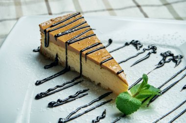 Mascarpone peynirli kekinin klasik bir dilimi New York 'ta beyaz bir tabakta ahşap arka planda. Kapat.