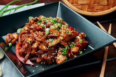 Bebek mısırlı erişte, dolmalık biber, soğan, havuç ve tavuklu kızarmış teriyaki soslu ahşap zemin. Lezzetli Asya sokak yemekleri