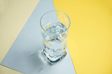 Renkli arka planda bir bardak temiz su. Saf su konsepti