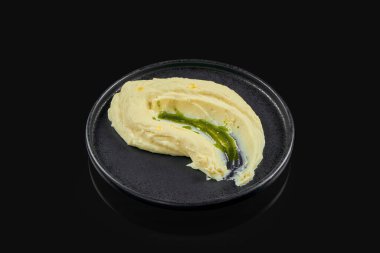 Klasik restoran usulü patates püresi. Pesto soslu patates püresi ve siyah arka planda siyah seramik tabakta zeytinyağı. Menü için fotoğraf. Garnitür
