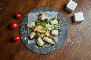 Mükemmel bir bira aperatifi, krem soslu, peynirli ve soğanlı fırında pişirilmiş midye setidir. Bar yemeği. Deniz ürünleri. Yeni Zelanda midyeleri