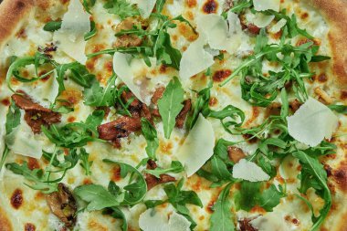 Yabani mantarlı fırında pizza, parmesan peyniri ve ahşap zemin üzerinde çıtır çıtır roka. Restoran masası. Üst görünüm, dokuyu kapat