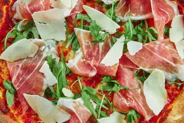 Prosciutto di parma, parmesan peyniri ve ahşap zemin üzerinde çıtır çıtır roka ile aperatif pizza. Restoran masası. Üst Manzara. Dokuyu kapat