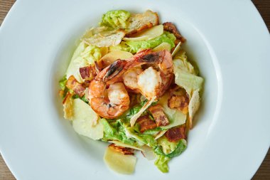 Sezar 'ı karides, pastırma, marul, parmesan ve kızarmış ekmekle iştah açıcı. Deniz ürünleri salatası. Görüntüyü kapat