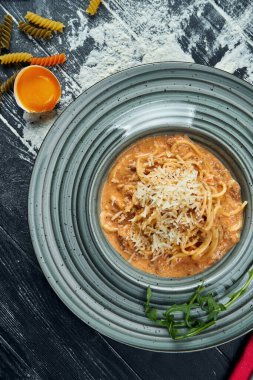 Kırmızı soslu ve kıymalı ev yapımı makarna, mavi tabakta parmesan. Yaklaş, üstten bak. İtalyan spagettisi, tarif için fotoğraf.