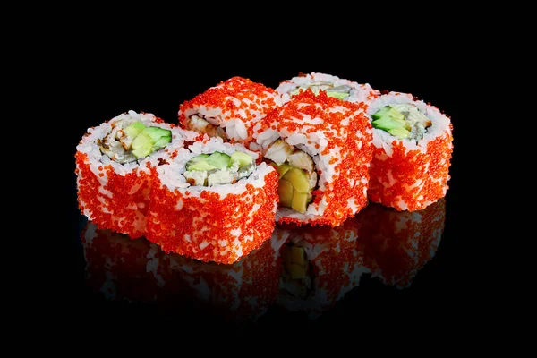 Sushi california roll with cucumber, avocado, eel and red tobiko caviar isolated on black with reflection. Close up. Japanese cuisine. Photo for menu