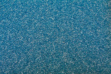 Mavi renkli bal peteği yapısı şeklinde bir arkaplan. Yakın çekim sünger. Parlak mavi parıltı dokusu..