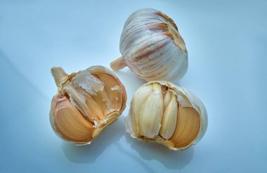 Açık mavi arka planda bir sürü sarımsak. Yakın plan.