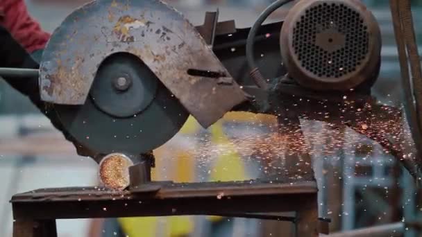 Primo piano di mani operaio industriale rettifica metallo con un sacco di affilato. Spara primo piano di segare un tubo con una macchina circolare arrugginita. Texture grunge. Un duro lavoro. Seghe elettriche e metallo. Scintille dentro — Video Stock