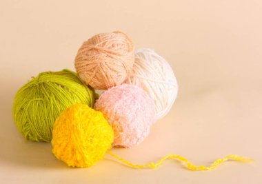 İplik tufts bej renkli bir arka plan üzerinde yalan. Bir desenle skeins iplik örme için. İğne işi için konu. Yatay görüntü.