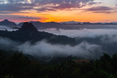 Dağ manzaralı sisli sabah ve gün doğumu manzaralı.