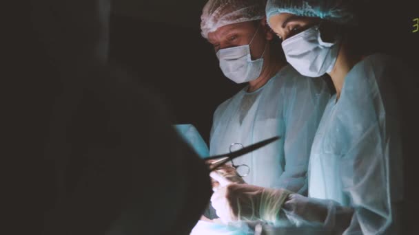 The senior surgeon in the operating room, where the patient is waiting for him, and he begins the operation. Real Modern Hospital with Authentic Equipment. — Stock Video